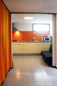 アルブフェイラにあるAcoteias Beach Studioのキッチン(オレンジ色のカーテン、ソファ付)