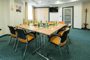 a conference room with a large wooden table and chairs at Kopernikus Hotel Prag in Belgrade