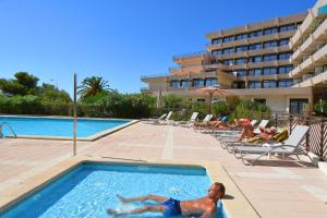 a man laying in a swimming pool at a hotel at Résidence Les Calanques in Ajaccio