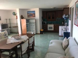Porto San Paolo Sea Villa في بورتو سان باولو: مطبخ وغرفة معيشة مع طاولة وأريكة