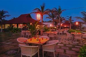 a restaurant with tables and chairs at night at The Park Visakhapatnam in Visakhapatnam