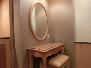 a bathroom with a stool and a mirror on the wall at Hotel Hyper Noah (Adult Only) in Sakai