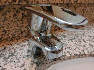 a chrome bathroom sink faucet on a counter at Hotel Hyper Noah (Adult Only) in Sakai