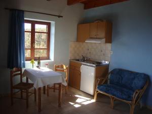a kitchen with a table and chairs and a kitchen with a table and a sink at Gavdos Princess in Gavdos
