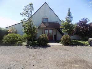 una casa bianca con una porta rossa di B&B De Polderhoeve a Blankenberge