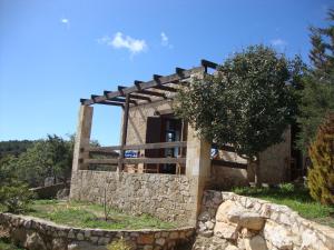 una casa de piedra con una pared de piedra alrededor en Gavdos Princess, en Gavdos