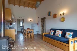 a living room with a blue couch and a kitchen at Akivillas Aljezur Nature in Aljezur