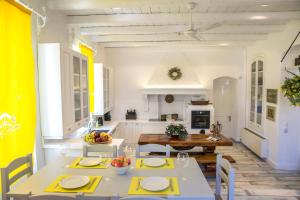 a kitchen and dining room with white tables and chairs at Anno 1900 in Corfu Town