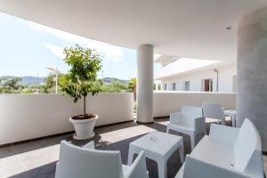 einen Balkon mit weißen Stühlen und einem Topfbaum in der Unterkunft Hotel Scialì in Vieste