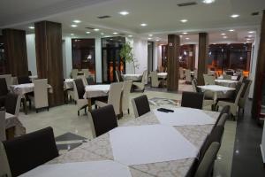 a dining room with white tables and chairs at Hotel Rio in Prishtinë