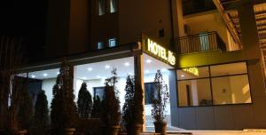 einen Laden in der Nacht mit einem beleuchteten Schild in der Unterkunft Hotel Rio in Pristina