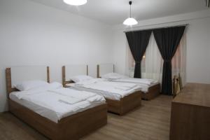 een slaapkamer met 3 bedden en een tafel bij Hotel Rio in Pristina +60 foto's