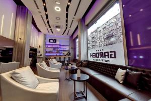a bar with white chairs and a couch and tables at Hotel Srbija Garden-FREE PARKING in Belgrade