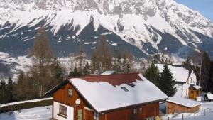 a house in front of a snow covered mountain at Krennbauer in Öblarn