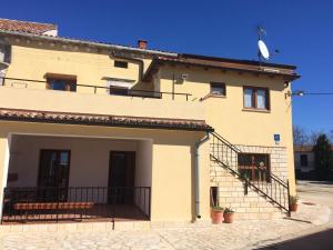 a large yellow building with a balcony and stairs at Apartment Anamarija in Poreč