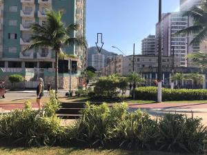 Ein Mann, der in einer Stadt auf einer Straße läuft in der Unterkunft Apartamento no Canto do Forte, Luxuoso e Confortável, 2 Suítes, Varanda Gourmet in Praia Grande