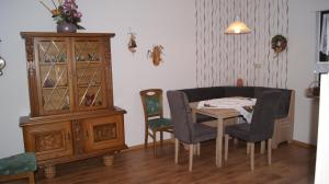 ein Esszimmer mit Tisch, Stühlen und einem Schrank in der Unterkunft Haus Straus in Sosberg