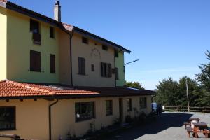 un bâtiment jaune avec un toit en tuiles rouges dans l'établissement La Nuvola sul Mare, à Vara Superiore