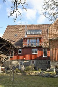 a large red house with a roof on top of it at Gemütliche Gästezimmer in einem neu sanierten Fachwerkhaus in Sachsenheim