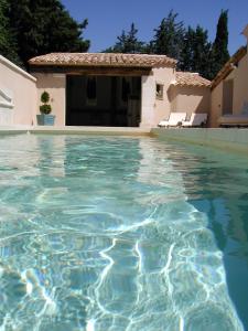 a swimming pool in front of a house at Chambre d'hôte Anais in Eyguières