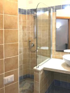 a bathroom with a glass shower and a sink at Sa Tirìa in Chia