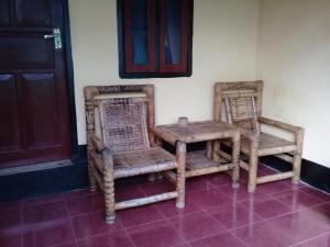 2 Stühle und ein Tisch in einem Zimmer in der Unterkunft Diyah Homestay in Kuta Lombok