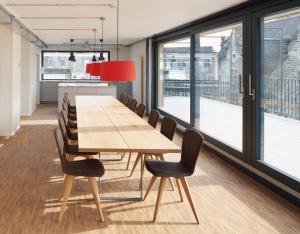 une salle de conférence avec une table et des chaises en bois dans l'établissement Josephine's Guesthouse - ! WOMEN ONLY !, à Zurich