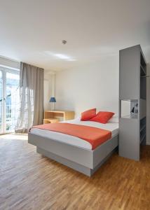 una camera da letto con un grande letto con cuscini rossi di Josephine's Guesthouse - ! WOMEN ONLY ! a Zurigo