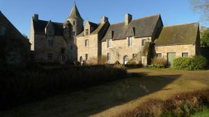 un antico edificio in pietra con tetto di Manoir de Kerguéréon a Ploubezre