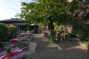 eine Terrasse mit Tischen, Stühlen und einem Baum in der Unterkunft Landgasthof zur Brücke in Wiesentheid