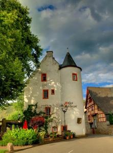 ein großes weißes Gebäude mit schwarzem Dach in der Unterkunft Moselwinzerhaus in Bruttig-Fankel