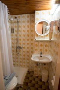 a bathroom with a sink and a shower and a mirror at International Hotel in Kos