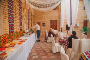 a group of people sitting at tables in a restaurant at Arba Hotel in Samarkand