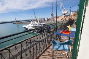 a table and two chairs on a balcony with a boat at casa Parisi in Imperia