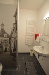 uma casa de banho com um lavatório, um WC e um chuveiro em Stadshotel Ootmarsum em Ootmarsum