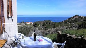 a table with a bottle of wine sitting on a balcony at Appartamento Nature Il Colle in Marciana