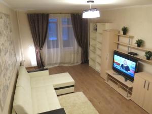 uma sala de estar com um sofá branco e uma televisão em City Inn Apartments - Baumanskaya em Moscou