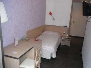 a small room with a bed and a desk at Hotel Renato in Sesto San Giovanni