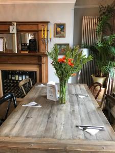 a wooden table with a vase of flowers on it at Bentinck Hotel in Nottingham