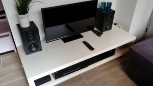 a white table with a tv and two speakers at Apartment Christian in Cologne