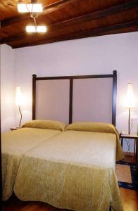 a bedroom with a large bed with two lamps at Posada Arco de San Miguel in Calatayud