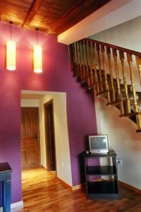 a living room with purple walls and a staircase at Posada Arco de San Miguel in Calatayud