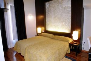 sypialnia z łóżkiem z dwoma światłami w obiekcie Posada Arco de San Miguel w mieście Calatayud