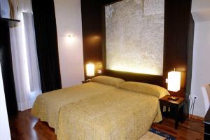 a bedroom with a bed with two lights on it at Posada Arco de San Miguel in Calatayud
