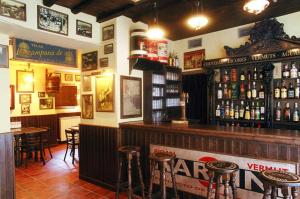 a bar with tables and stools in a restaurant at Posada Arco de San Miguel in Calatayud