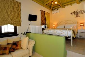 uma sala de estar com uma cama e um sofá em Villa Kerasia em Miléai mais 32 fotografias