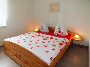 ein Schlafzimmer mit einem Bett mit roten Blumen darauf in der Unterkunft Ferienwohnungen "Am Elbufer" in Bad Schandau