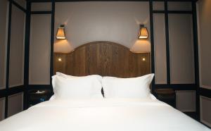 a bedroom with two beds with white sheets and lights at Mimi's Hotel Soho in London