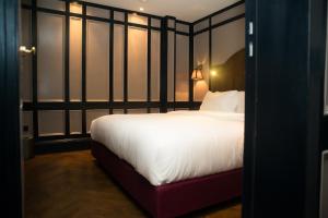 a bedroom with a large white bed and some windows at Mimi's Hotel Soho in London
