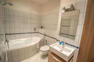 a bathroom with a tub toilet and a sink at Ruterra Apartment Charles Bridge in Prague